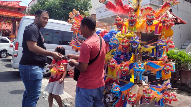 Pedagang ornamen berbau Imlek berjualan di sekitaran kawasan Pecinan di Kota Manado, Sulawesi Utara.