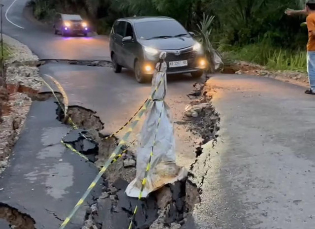 Pengendara roda empat saat berusaha melewai Jalan Embaong-Sungai Batu yang ambruk sebagian karena longsor. Foto: Dok. instagramm @sanggau_informasi