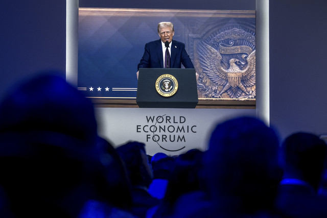 Presiden AS Donald Trump terlihat di layar raksasa selama pidatonya melalui konferensi video di pertemuan tahunan Forum Ekonomi Dunia (WEF) di Davos pada 23 Januari 2025.  Foto: Fabrice Coffrini/AFP