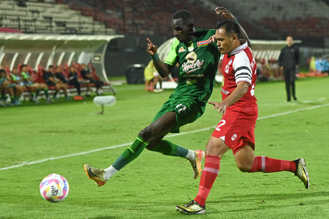 Pesepak bola Persebaya Surabaya Flavio Silva (kiri) berebut bola dengan pesepak bola PS Barito Putera Novan Setya Sasongko (kanan) saat pertandingan Liga 1 2024/2025 di Stadion Kapten I Wayan Dipta, Gianyar, Bali, Sabtu (25/1/2025). Foto:  ANTARA FOTO/Fikri Yusuf