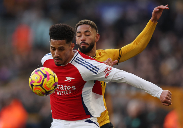 William Saliba duel dengan Matheus Cunha saat Wolves vs Arsenal dalam laga pekan ke-23 Liga Inggris 2024/25 di Stadion Molineux, Sabtu (25/1) malam WIB. Foto: REUTERS/Chris Radburn