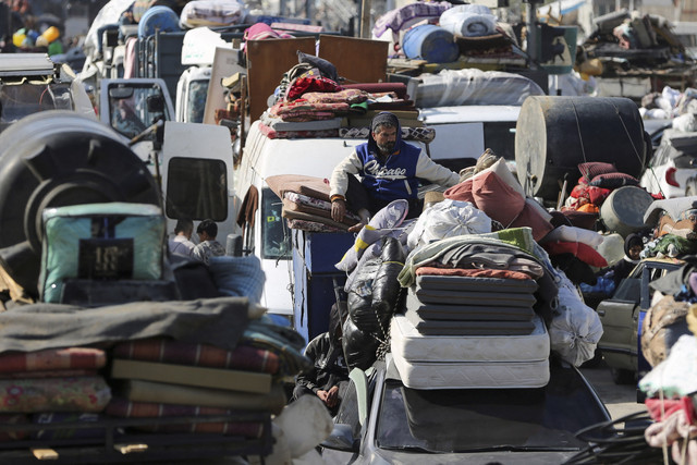 Seorang pria duduk saat warga Palestina menunggu untuk diizinkan kembali ke rumah mereka di Gaza tengah, Minggu (26/1/2025). Foto: Hatem Khaled/REUTERS