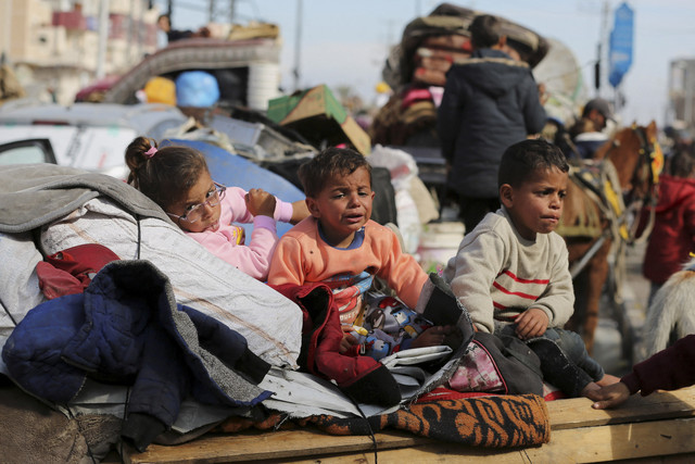 Anak-anak Palestina menunggu untuk diizinkan kembali ke rumah mereka di Gaza utara, Minggu (26/1/2025). Foto: Hatem Khaled/REUTERS