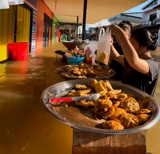 Warga Ngabang beli gorengan saat banjir. Foto: Dok, Instagram @aminx_bangor