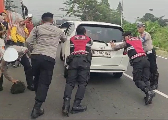 Anggota kepolisian Polres Kuningan saat mendorong kendaraan wisatawan yang tidak kuat menanjak, Senin (27/1/2025). Dok: Ist