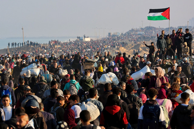 Warga Palestina melintasi koridor Netzarim dari Jalur Gaza selatan ke utara menuju Kota Gaza di sepanjang Jalan al-Rashid di pesisir Gaza, Senin (27/1/2025). Foto: Omar AL-QATTAA / AFP