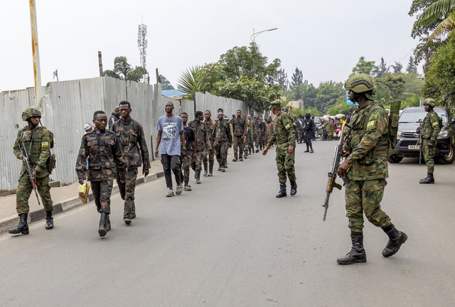 Petugas keamanan Rwanda mengawal anggota Angkatan Bersenjata Republik Demokratik Kongo (FARDC) yang menyerah, setelah pertempuran antara pemberontak M23 dan Angkatan Bersenjata Republik Demokratik Kongo (FARDC) di Gisenyi, Rwanda, Selasa (27/1/2025). Foto: Jean Bizimana/REUTERS