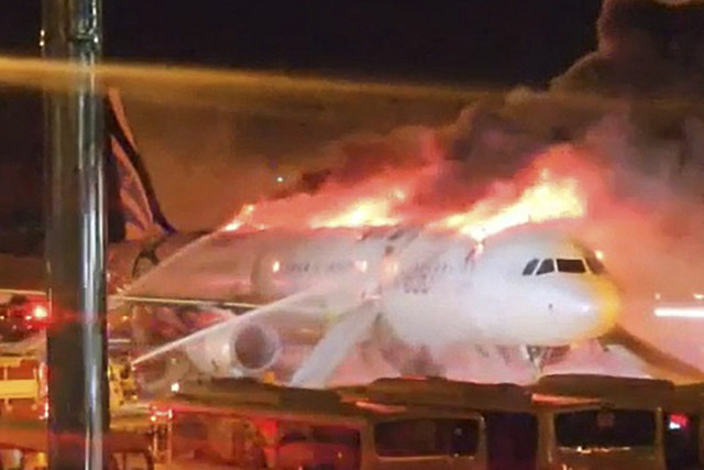 Petugas pemadam kebakaran berusaha memadamkan api yang membakar pesawat penumpang Air Busan di Bandara Internasional Gimhae, Busan, Korea Selatan, Selasa (28/1/2025). Foto: Yonhap via AFP