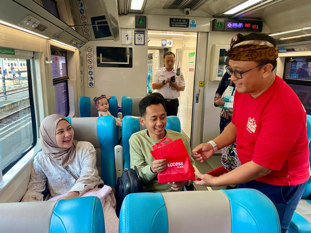 Pemberian kue keranjang kepada penumpang kereta api di Stasiun Surabaya Gubeng, Rabu (29/1).