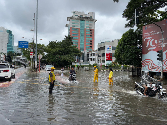 Pengendara melintasi jalan Panjang, Kedoya Utara, Kebon Jeruk, Jakarta Barat dekat kompleks perumahan Green Garden masih tergenang banjir pada Rabu (29/1). Foto: Abid Raihan/kumparan