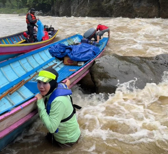 Kepala Dinas Pendidikan dan Kebudayaan Provinsi Kalbar, Rita Hastarita menyeret perahu kayu saat menuju ke SDN 11 Tanjung Lokang. Foto: Dok. Istimewa