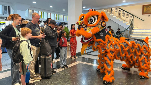 Wisatawan asing takjub saksikan pertunjukan barongsai di stasiun Yogyakarta dalam rangka perayaan Tahun Baru Imlek 2025. (Foto: M Wulan)