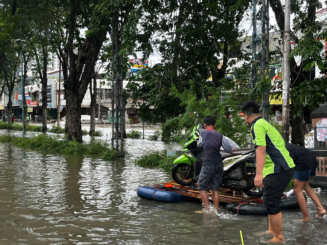 Pengguna motor menggunakan rakit buatan untuk melintasi banjir di jalan Hibrida, Kelapa Gading, Jakarta Utara, Rabu (29/1). Foto: Rayyan Farhansyah/kumparan