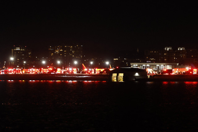 Lampu-lampu dari kendaraan darurat terlihat di Bandara Nasional Reagan di Washington, DC, setelah kecelakaan udara di dekat Sungai Potomac pada tanggal 29 Januari 2025.  Foto: TING SHEN/AFP