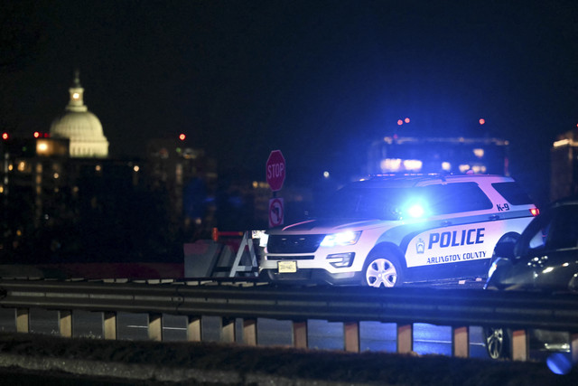 Gedung Kongres AS terlihat di kejauhan saat sebuah kendaraan polisi memblokir pintu masuk ke Sungai Potomac di dekat Bandara Nasional Reagan setelah sebuah kecelakaan udara di Washington, DC, pada 29 Januari 2025. Foto: Andrew Caballero-Reynolds/AFP