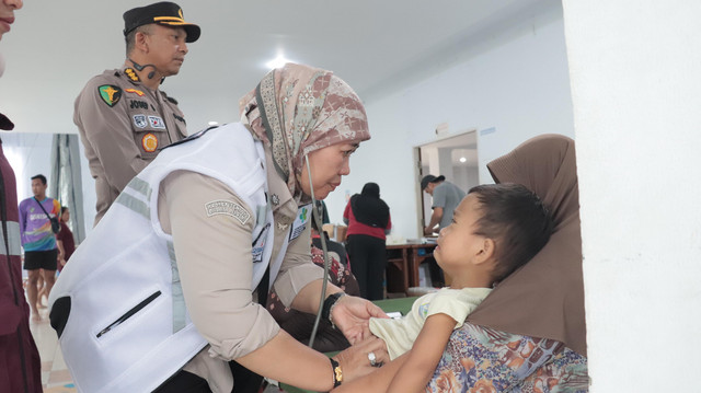 Kadinkes Kalbar, dr. Erna Yulianti saat memeriksa salah satu anak di Posko pengungsian banjir, di Wisma Chandramidi Mempawah. Foto: Dok. Dinkes Kalbar