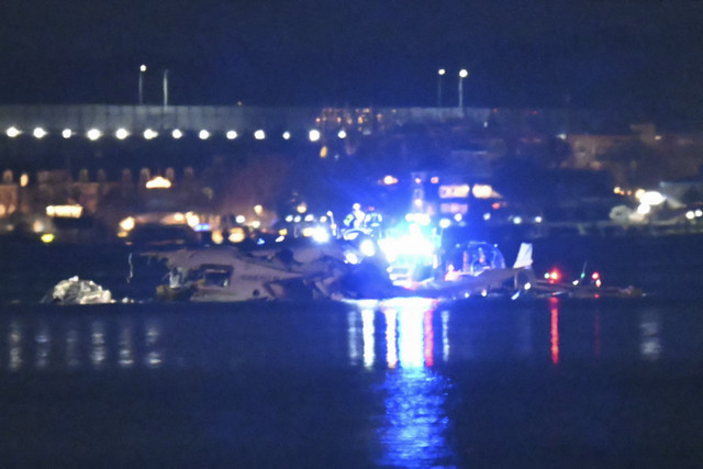 Puing-puing terlihat saat kapal penyelamat mencari di perairan Sungai Potomac setelah sebuah pesawat yang sedang mendekati Bandara Nasional Reagan jatuh ke sungai di luar Washington, DC, 30 Januari 2025. Foto: Andrew Caballero-Reynolds/AFP