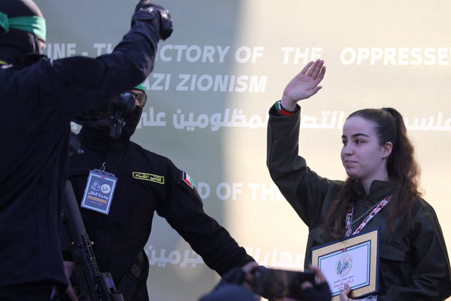 Militan Hamas membebaskan tentara wanita Israel Agam Berger ebagai bagian dari gencatan senjata dan kesepakatan pertukaran sandera-tahanan antara Hamas dan Israel di Jabalia, Jalur Gaza utara, Kamis (30/1/2025). Foto: Dawoud Abu Alkas/REUTERS