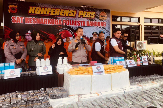 Polisi menunjukkan barang bukti dan tersangka kasus peredaran miras dan obat-obatan saat konferensi pers di Mapolresta Bandung, Kamis (30/1/2025). Foto: Robby Bouceu/kumparan