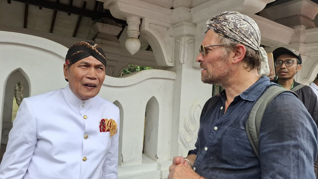 Carik Kawedanan Perintah Ageng Keraton Yogyakarta, Kanjeng Raden Tumenggung (KRT) Wijoyo Pamungkas saat mengobrol dengan wisatawan asing di Pantai Parangkusumo, pada Kamis (30/1/2025)(Foto. Olive)