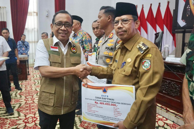 Menko PMK Pratikno menyerahkan bantuan kepada Pj Bupati Mempawah. Foto: Dok. Istimewa