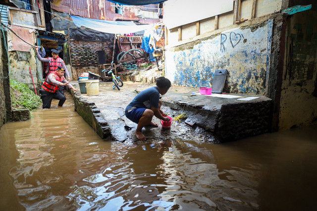 Warga beraktivitas ditengah banjir yang mulai surut di kawasan Kampung Kebon Pala, Kampung Melayu, Jakarta TImur, (31/1/2025). Foto: Iqbal Firdaus/kumparan