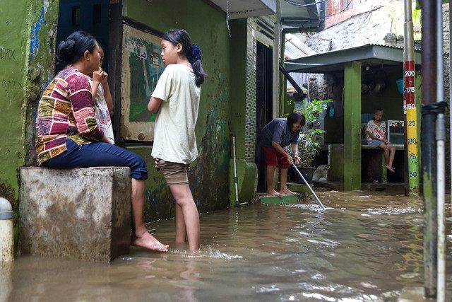 Warga beraktivitas ditengah banjir yang mulai surut di kawasan Kampung Kebon Pala, Kampung Melayu, Jakarta TImur, (31/1/2025). Foto: Iqbal Firdaus/kumparan