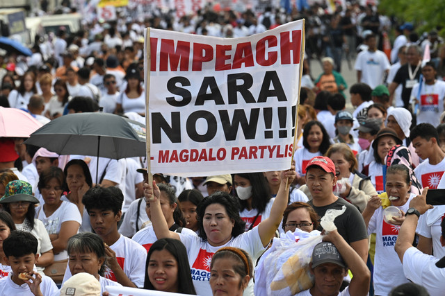 Para pengunjuk rasa memegang poster saat unjuk rasa di monumen People Power di Manila pada tanggal 31 Januari 2025, untuk mendukung pengaduan pemakzulan terhadap Wakil Presiden Filipina Sara Duterte. Foto: Ted ALJIBE / AFP