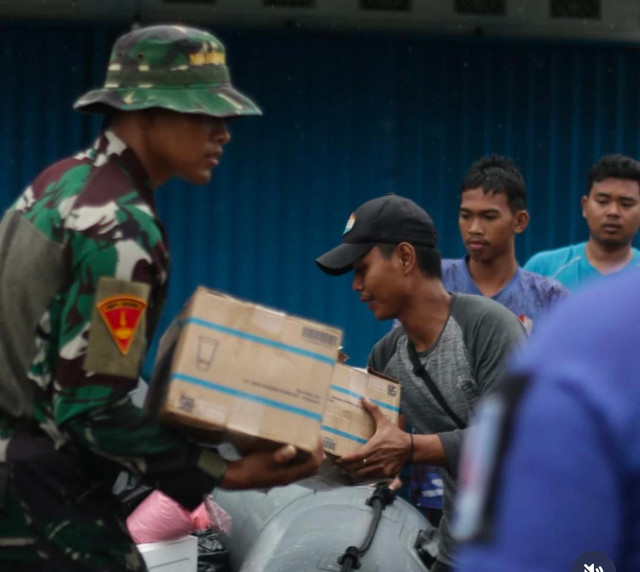 Personel TNI saat membantu membagikan bantuan bahan makanan kepada warga yang terdampak banjir di Mempawah. Foto: Dok, Instagram @ermin.elviani