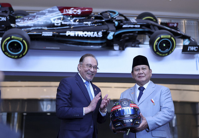 Presiden Indonesia Prabowo Subianto memegang helm Mercedes AMG Petronas F1 Team sebagai kenang-kenangan dari mitranya dari Malaysia, Anwar Ibrahim, saat kunjungan Presiden Indonesia ke Malaysia di Kuala Lumpur, Malaysia, 27 Januari 2025. Foto: Hasnoor Hussain/REUTERS