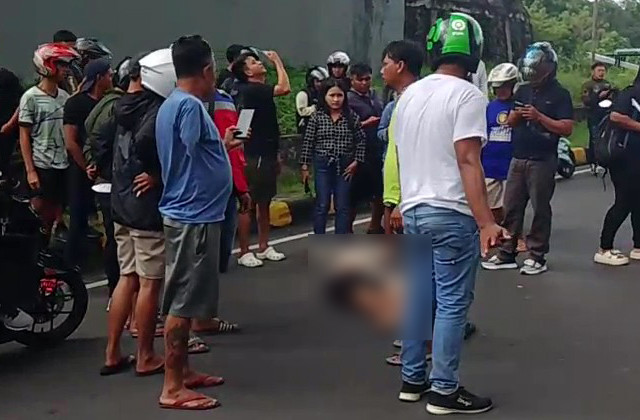 Warga mengitari seorang wanita yang diduga melompat dari atas jembatan Interchange Manado, Sabtu (1/2).