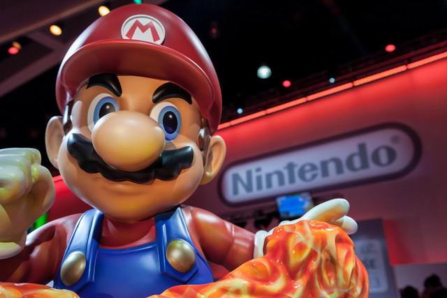 Ilustrasi patung Super Mario raksasa dan logo Nintendo. Foto: Shutterstock