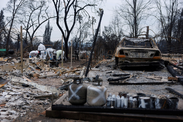 Petugas Badan Perlindungan Lingkungan (EPA) membersihkan puing-puing beracun dan berbahaya dari rumah yang terbakar setelah Kebakaran Eaton di Altadena, California, Amerika Serikat, Kamis (30/1/2025).  Foto: Mike Blake/REUTERS