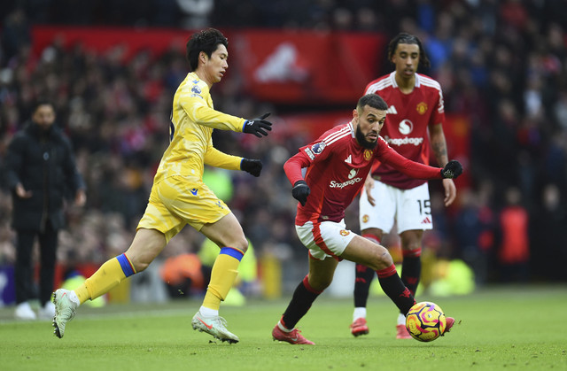 Pemain Manchester United, Noussair Mazraoui, beraksi dengan pemain Crystal Palace, Daichi Kamada pada pertandingan Liga Inggris antara Manchester United vs Crystal Palace di Old Trafford, Manchester, Inggris, Minggu (2/2/2025). Foto: Peter Powell/REUTERS