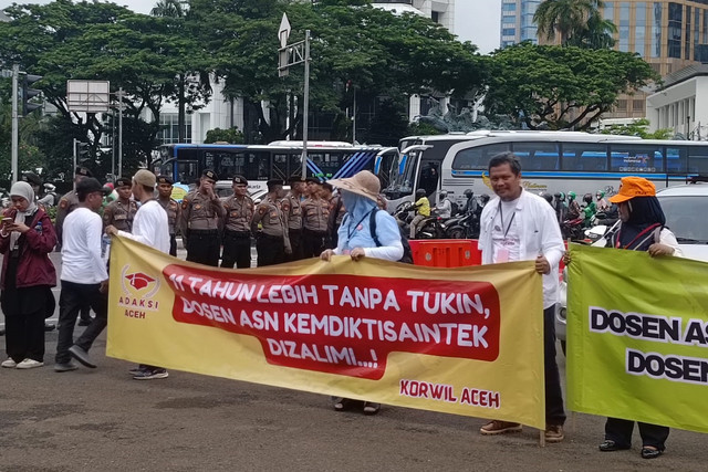 Massa aksi yang terdiri dari dosen Aparatur Sipil Negara (ASN) menggelar aksi di kawasan Monas, Jakarta, Senin (3/2/2025).  Foto: Zamachsyari/kumparan