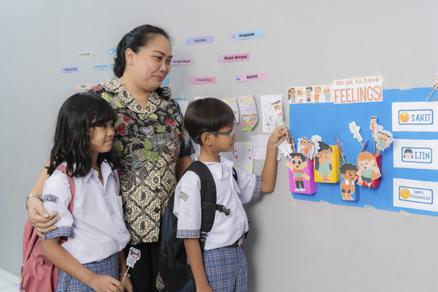 Bu Galuh sedang mendampingi anak mengisi papan tentang perasaan yang mereka rasakan sebelum pembelajaran dimulai. Foto: Bakti Pendidikan Djarum Foundation