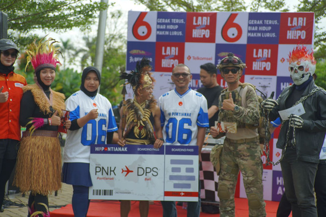 CEO HiPontianak Group Leo Prima dan Komisaris PT Kapuas Media Sarana Listya Sekar Siwi, menyerahkan hadiah pada event Lari Bareng HiPo. Foto: Dok. Hi!Pontianak