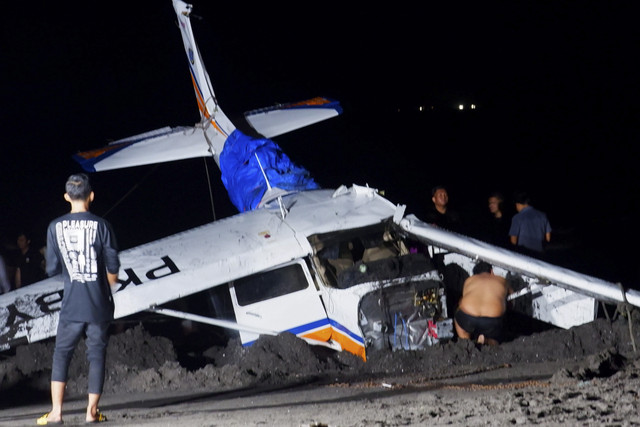 Sejumlah petugas bersama warga mengevakuasi pesawat Cessna 172s Skyhawk yang jatuh di Pantai Gumuk Kantong, Muncar, Banyuwangi, Jawa Timur, Selasa (4/2/2025). Foto: Budi Candra Setya/ANTARA FOTO