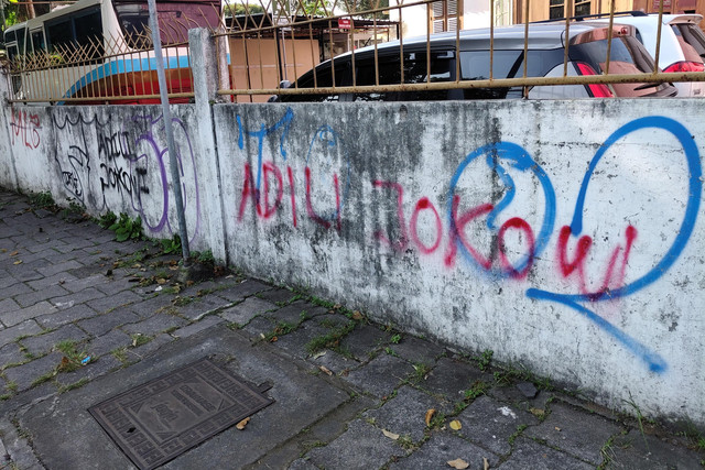 Tulisan "Adili Jokowi" muncul di tembok trotoar Jalan Sultan Agung, Kota Yogyakarta, Rabu (5/2/2025). Foto: Arfiansyah Panji Purnandaru/kumparan