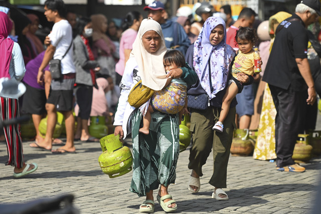 Warga membawa gas elpiji 3 kg yang dibeli saat operasi pasar di kawasan Tuban, Badung, Bali, Rabu (5/2/2025). Foto: Fikri Yusuf/ANTARA FOTO