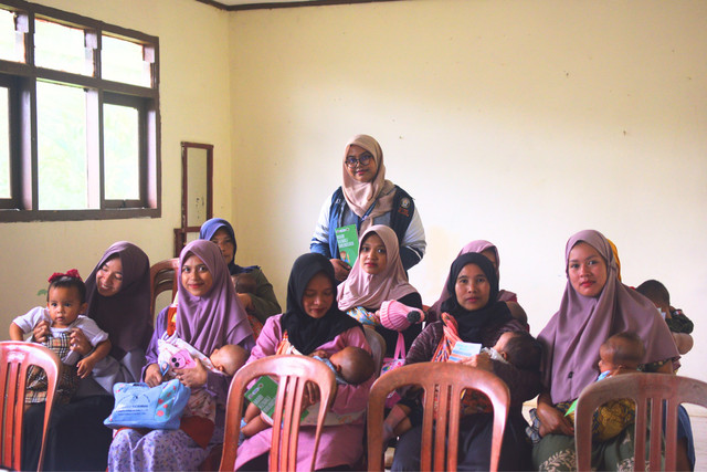 Mahasiswa KKN Tim 1 Universitas DIponegoro, Annisa Farah Adhaliani bersama ibu dengan bayi dan balita di Gedung Pos Kesehatan Desa Pengarengan, Kecamatan Kalibawang, Kabupaten Wonosobo. (21/01/2025)