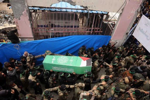 Milisi Hamas membawa peti Marwan Issa, salah satu pemimpin militer Hamas yang tewas pada Maret 2024 lalu. Prosesi pemakamannya dilangsungkan di kamp pengungsian Bureij, Gaza, Jumat (7/2). Foto: Eyad BABA / AFP