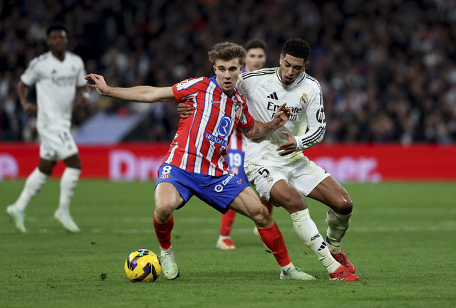 Pablo Barrios dari Atletico Madrid beraksi dengan pemain Real Madrid, Jude Bellingham pada pertandingan Liga Spanyol antara Real Madrid vs Atletico Madrid di Santiago Bernabeu, Madrid, Spanyol, Minggu (9/2/2025) dini hari WIB. Foto: Violeta Santos Moura/REUTERS