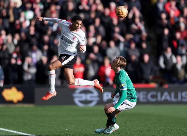 Pemain Liverpool Jarell Quansah berebut bola dengan pemain Plymouth Argyle Callum Wright pada pertandingan Putaran Keempat Piala FA di Home Park, Plymouth, Inggris, Minggu (9/2/2025). Foto: David Klein/REUTERS