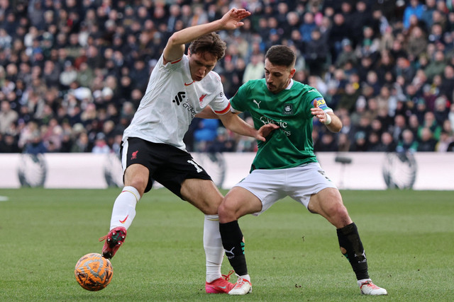 Pemain Liverpool Federico Chiesa berebut bola dengan pemain Plymouth Argyle Julio Pleguezuelo pada pertandingan Putaran Keempat Piala FA di Home Park, Plymouth, Inggris, Minggu (9/2/2025). Foto: David Klein/REUTERS