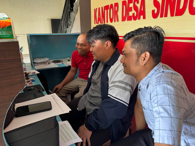 Mahasiswa KKN UNDIP memberikan bimbingan langsung kepada perangkat desa dalam penggunaan Canva di Balai Desa Sindukarto, Jumat (07/02/2025) (foto: Dok KKN).