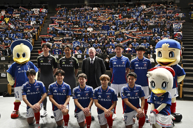 Pelatih kepala sepak bola baru Yokohama F. Marinos Steve Holland (C) menghadiri sesi foto bersama dengan timnya saat konferensi pers di Kantor Pusat Nissan Global di Yokohama (11/1/2025). Foto: Philip Fong/AFP