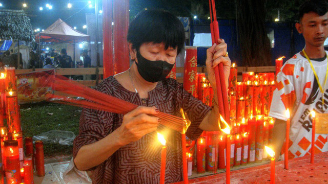 Seorang warga Tionghoa yang memanfaatkan momen Cap Go Meh di Pulau Kemaro Palembang dengan membakar dupa di Kelenteng, Senin (10/2) Foto: anye/urban id