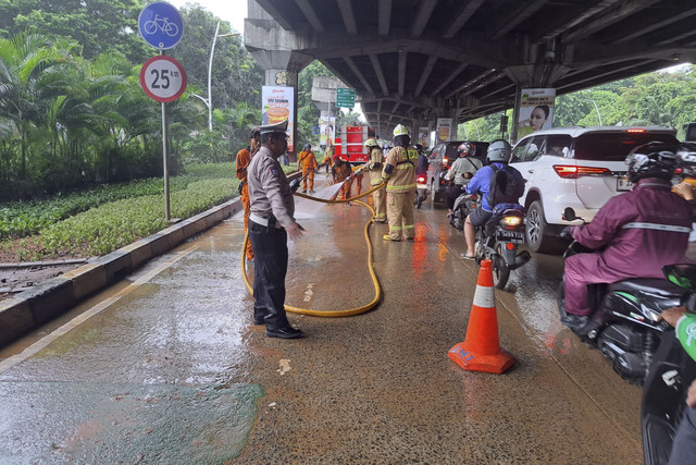 Petugas membersihkan material tanah di depan Artha Gading Mal, Jakarta Utara, Selasa (11/2/2025). Foto: Dok. Satlantas Polres Jakarta Utara