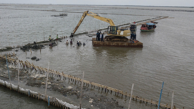 Operator alat berat escavator dari PT TRPN membongkar pagar laut dengan pengawasan Polisi Khusus Pengelolaan Pesisir dan Pulau-pulau kecil (Polsus PWP3K) Ditjen PSDKP di pesisir laut Tarumajaya, Kabupaten Bekasi, Jawa Barat, Selasa (11/2/2025). Foto: ANTARA FOTO/Fakhri Hermansyah